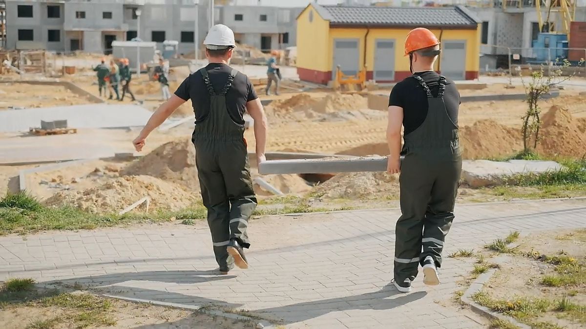 Two workers walking across a residential job site